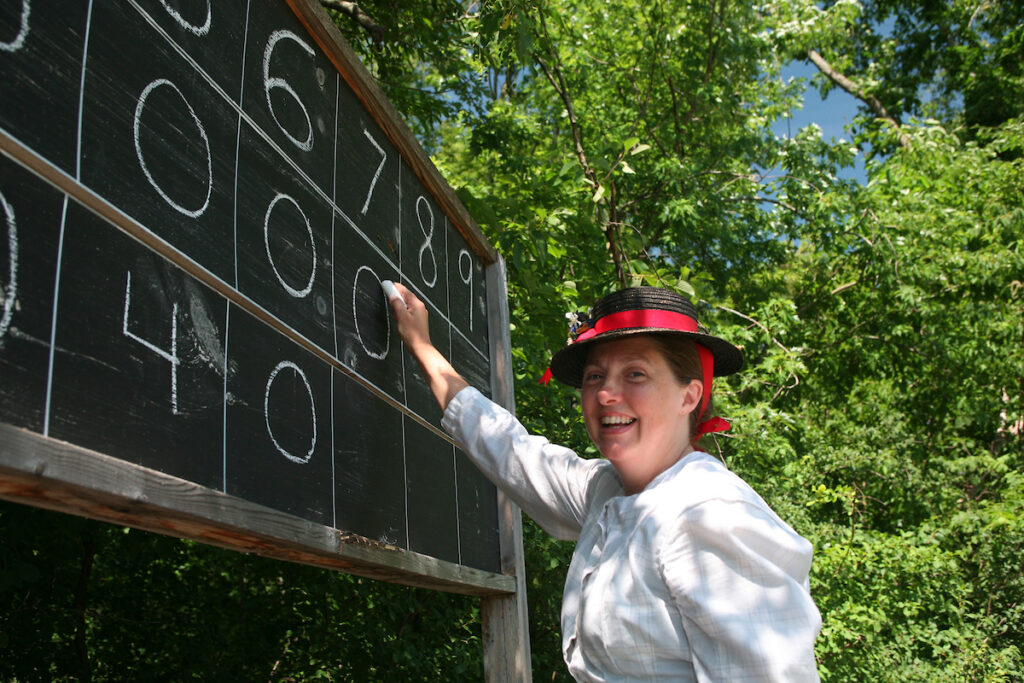 A woman keeps track of the score during a game of historic baseball at Old World Wisconsin. 