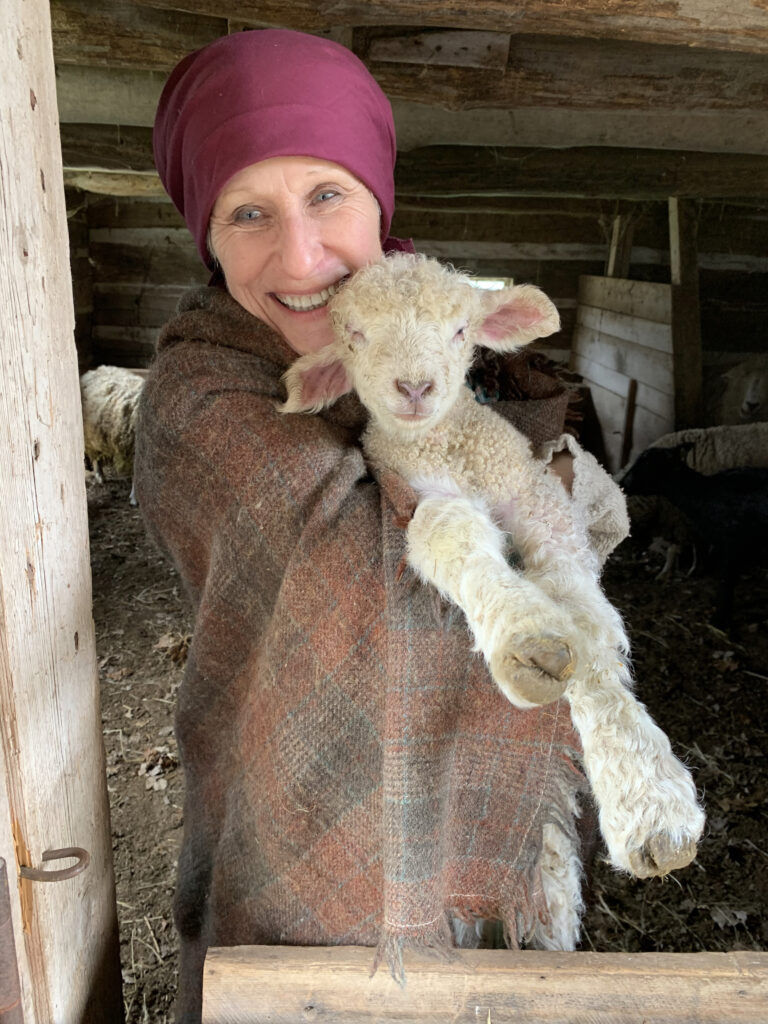 A woman holding a lamb during her employment at Old World Wisconsin